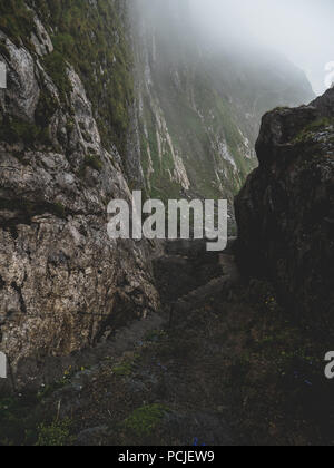 scary steep hiking path with stairs on steep mountain. hiking path sign on a stone, brienzer rothorn switzerland Stock Photo