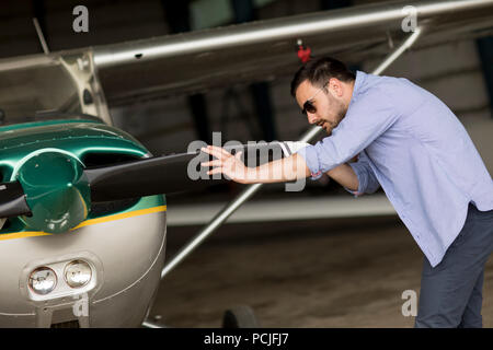 Handsome young pilot checking ultralight airplane before flight Stock Photo