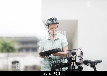 Woman replacing the battery on her e-bike Stock Photo