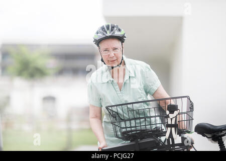 Woman replacing the battery on her e-bike Stock Photo