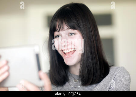 Portrait of a smiling woman looking at a digital tablet Stock Photo