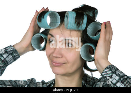 fifty-year-old woman holding hair curlers on her hair Stock Photo