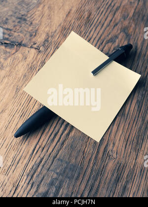 Sticky note with a pen on a table, close up shot, high angle view Stock Photo
