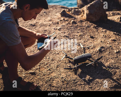 back of man holding controller and control drone take off on the mountain Stock Photo