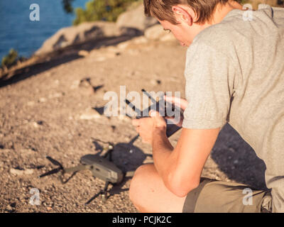 back of man holding controller and control drone take off on the mountain Stock Photo