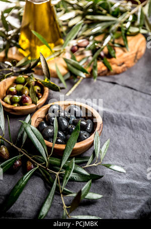 OLIVES. Olives, olives tree branch. olive oil on linen tablecloth Stock Photo