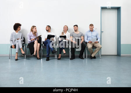 Candidates Sitting On Chair Waiting For An Interview Stock Photo