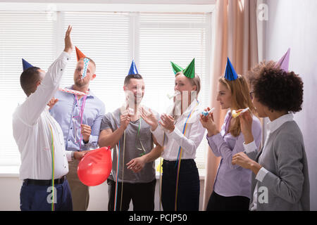 Group Of Young Businesspeople Celebrating New Year Party In Office Stock Photo
