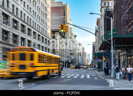 Yellow bus blurred in motion driving fast down Fifth Avenue in Manhattan New York City NYC Stock Photo