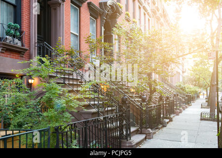 Sunlight shines on historic brownstone buildings in Manhattan New York City NYC Stock Photo