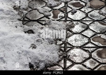 Spring thaw in the area covered with paving tiles. Stock Photo