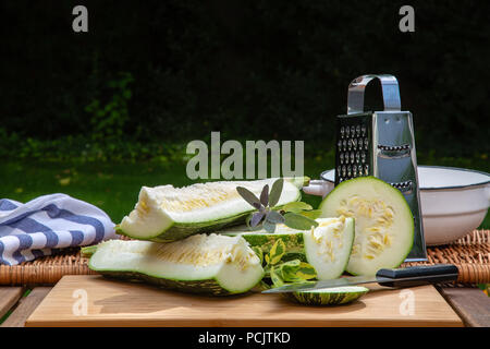 Chopped large spotted zucchini in the garden on the table Stock Photo