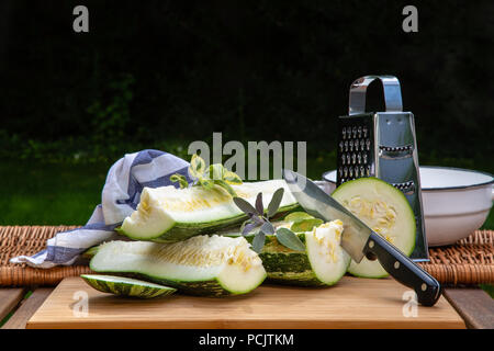 Chopped large spotted zucchini in the garden on the table Stock Photo