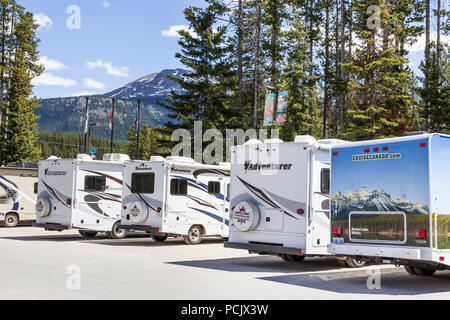 Motor homes in a car park in the Rocky Mountains at the town of Lake Louise, Alberta, Canada Stock Photo