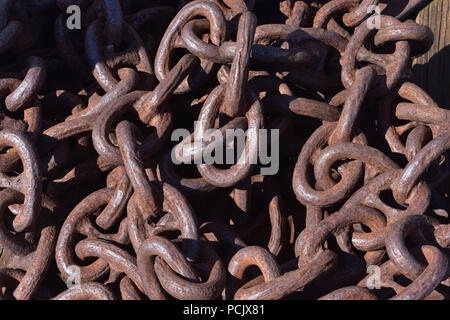 Rusting and corroding heavy link chain in a large pile. Stock Photo