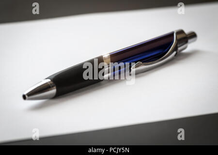 Office ballpoint pen lies on a sheet of paper close-up. Stock Photo