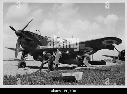 Image from a photo album relating to II. Gruppe, Jagdgeschwader 3: A French Morane-Saunier MS406-C1 fighter provides the perch for a Luftwaffe Obergegreiter of II./JG 3, on a captured airfield in France, summer 1940. Stock Photo