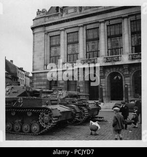 Image from a photo album relating to II. Gruppe, Jagdgeschwader 3: A Panzer III with a broken track sits behind a Panzer IV in a French town in summer 1940 Stock Photo