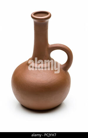 A small brown clay jug close-up on a white background. Stock Photo