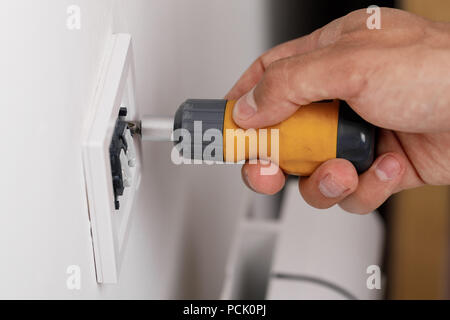 electrician installing light switch Stock Photo