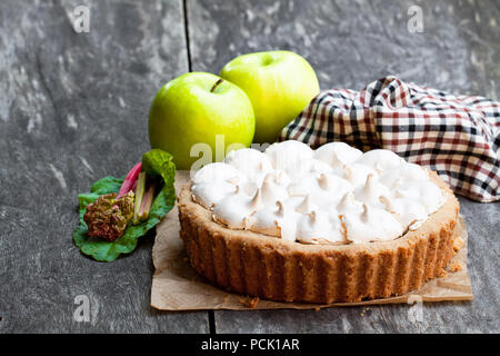 Tasty  meringue pie with rhubarb and apple on wooden table Stock Photo