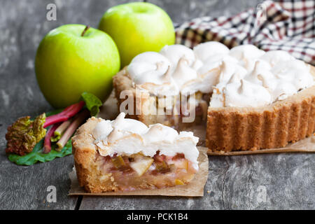 Tasty  meringue pie with rhubarb and apple on wooden table Stock Photo