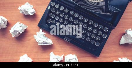 Writer's block concept with typewriter and crumpled paper on work desk Stock Photo