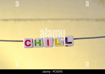 A Studio Photograph of Alphabetical Beads Suspended on a Wire Spelling 'Chill' Stock Photo