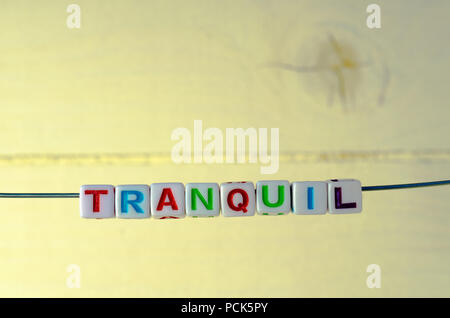 A Studio Photograph of Alphabetical Beads Suspended on a Wire Spelling 'Tranquil' Stock Photo