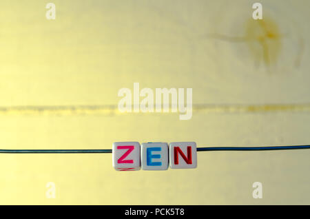 A Studio Photograph of Alphabetical Beads Suspended on a Wire Spelling 'Zen' Stock Photo