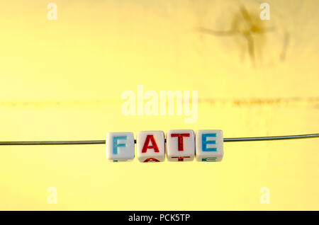 A Studio Photograph of Alphabetical Beads Suspended on a Wire Spelling 'Fate' Stock Photo