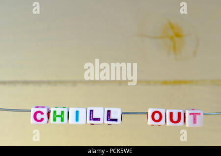 A Studio Photograph of Alphabetical Beads Suspended on a Wire Spelling 'Chill Out' Stock Photo
