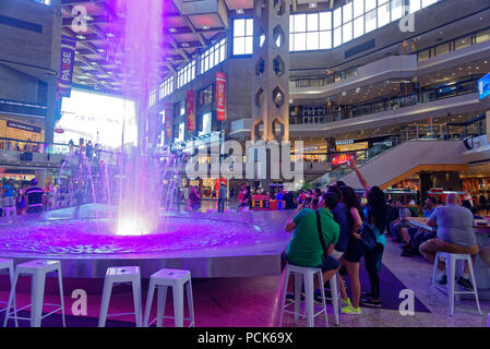 A group of young people taking photos of a large fountain in the Complexe Desjardins shopping centre in downtown Montreal Stock Photo