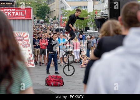 Crowds gather to watch a three wheel unicycle at the Just For Laughs festival in Montreal Stock Photo