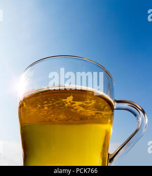 A mug of beer in the sun against a blue sky. Stock Photo