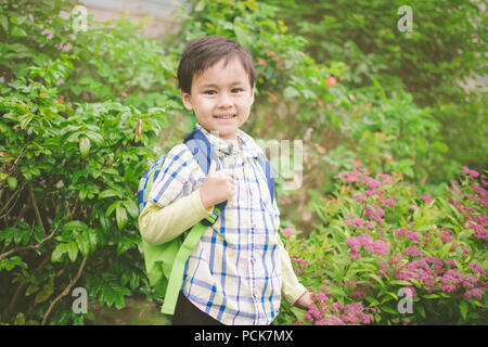 Young Boy Holding A Backpack Is Excited To Go Back To School Stock Photo