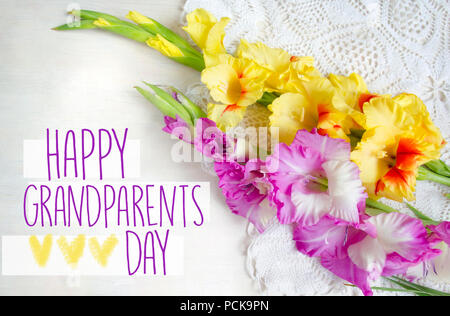 Beautiful gladiolus on wooden background. Bouquet of colored gladioli. Happy grandparents day. Stock Photo