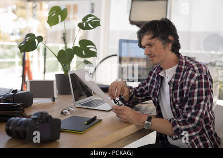 Photographer sitting at desk in the photo studio Stock Photo