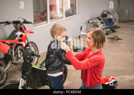 Mother preparing her son for bike riding Stock Photo