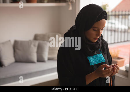 Muslim woman praying with prayer beads Stock Photo