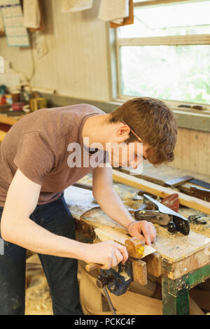 Male carpenter using marking gauge in workshop Stock Photo