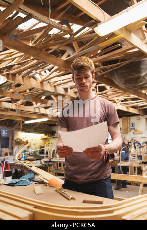 Male carpenter looking at chart in workshop Stock Photo