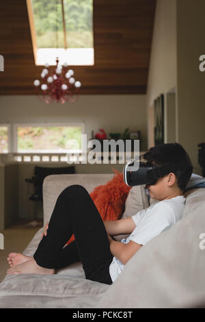 Boy using virtual reality headset in living room Stock Photo