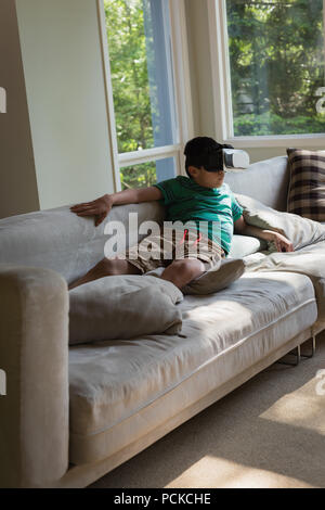 Boy using virtual reality headset in living room Stock Photo