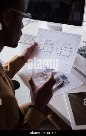 Male office executive checking blueprint on desk at creative office Stock Photo