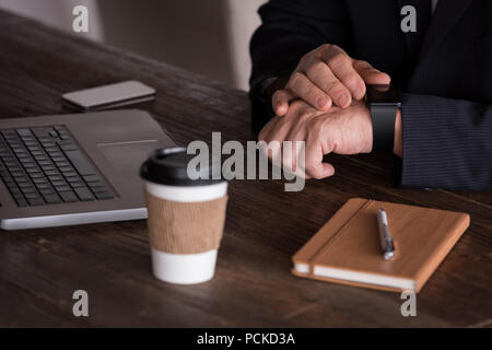 Businessman checking smart watch in creative office Stock Photo