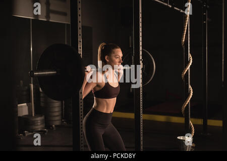 Woman lifting with barbell in gym Stock Photo