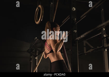 Woman doing pull-ups at the gym Stock Photo