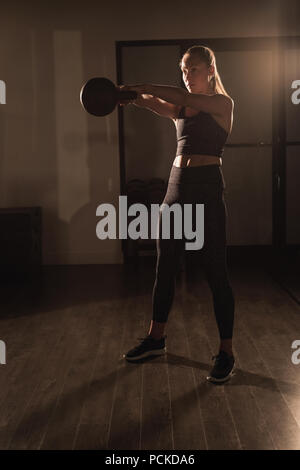 Woman doing exercises with kettlebell Stock Photo