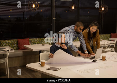 Business colleagues discussing over laptop Stock Photo